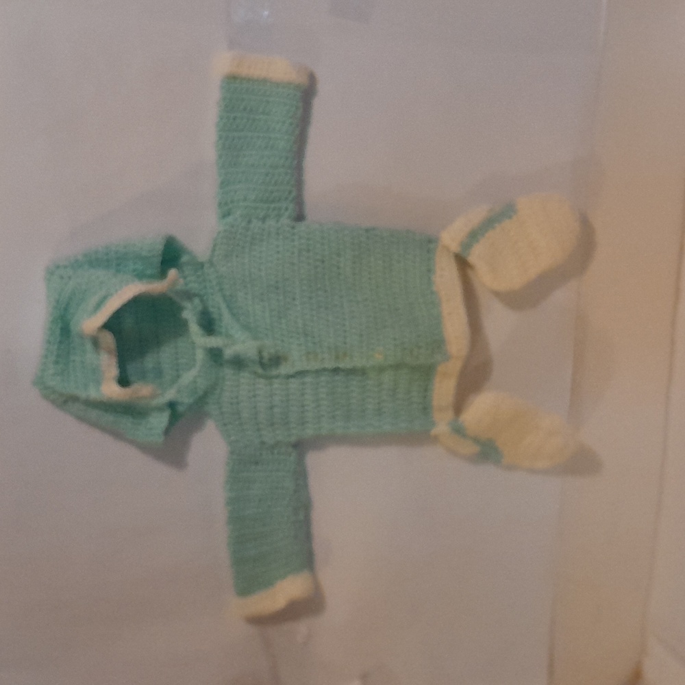 A light gren and cream color baby hoodie.
